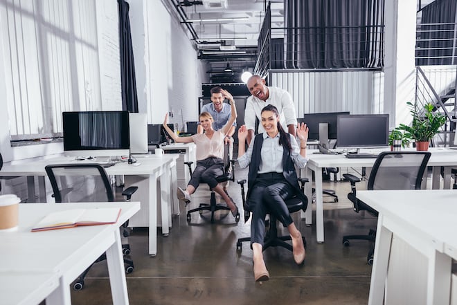 Workers pushing each other on a chair