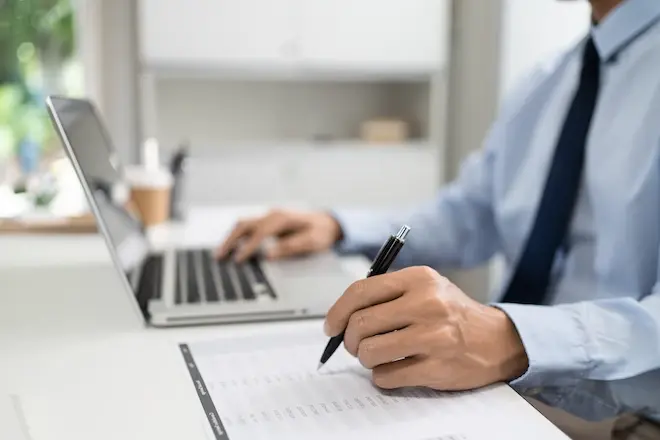 Office worker writing on notepad